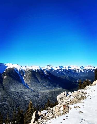 Panoramic view of snow-capped mountains under a clear blue sky.