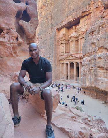 Person sitting in front of the Petra Treasury in Jordan.