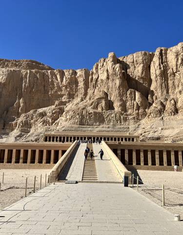 Mortuary Temple of Hatshepsut with tourists walking up the ramp.