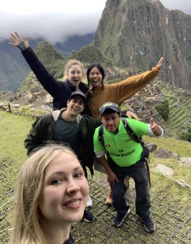 Group taking a selfie with Machu Picchu in the background.