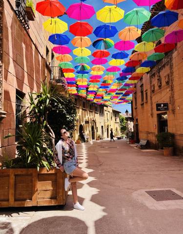 Colorful umbrellas hanging over a quaint street
