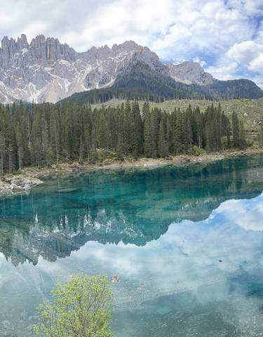 Clear blue lake surrounded by dense forest.
