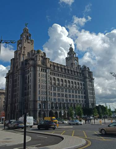 A historical building with towers against a cloudy sky.