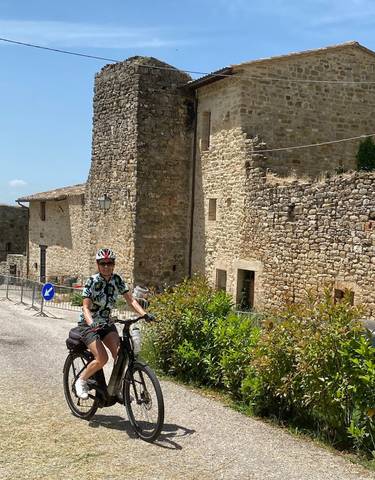 Cyclist in front of old stone buildings