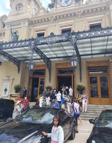 Elegant building entrance with a clock and people milling around.