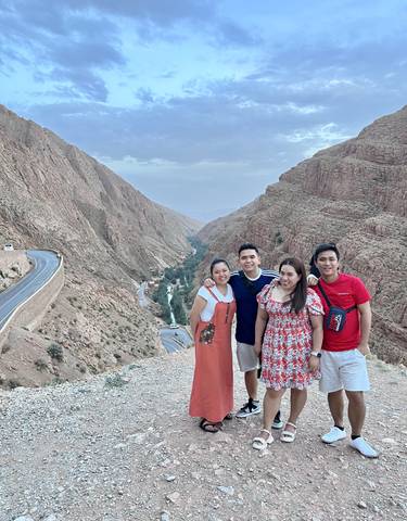 Four people on a mountain with valley views.