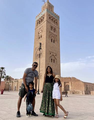 Family posing in front of a tall historic tower.