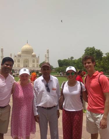 Group of people posing in front of the Taj Mahal.