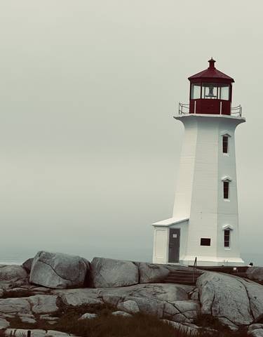 Tall lighthouse with a red top against a gray sky.