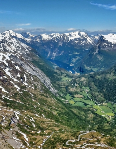 A breathtaking view from a high altitude of snow-capped mountains and a valley.