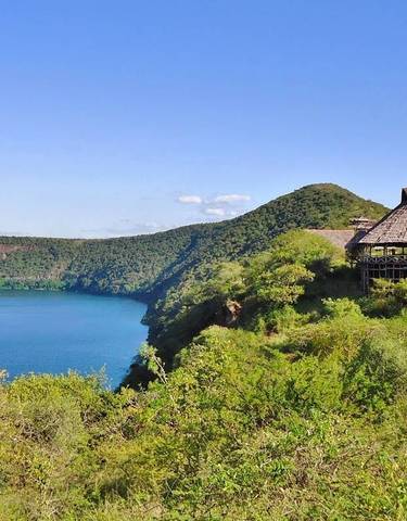 A lodge overlooking a scenic view with water and hills.