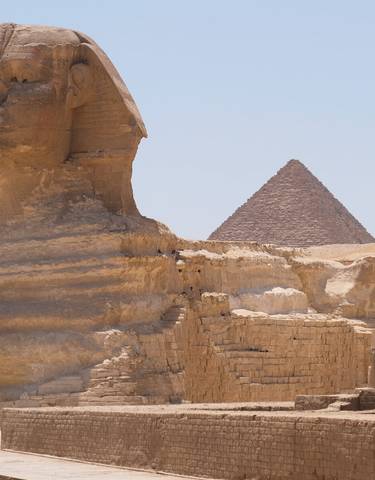 The Great Sphinx of Giza with a pyramid in the background.