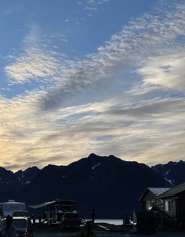 Silhouette of mountains with a cloudy sky during sunset.
