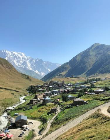 Village nestled in a mountainous region with snow-capped peaks.