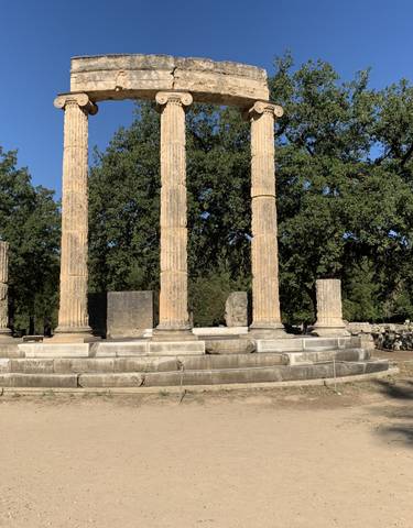 Ruins of ancient Greek columns and structures in an archaeological site.