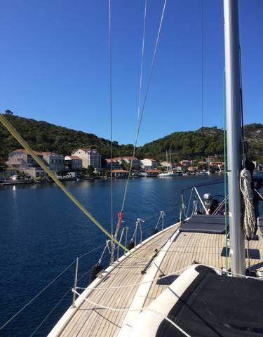 Coastal village with boats docked in a harbor under a clear sky.