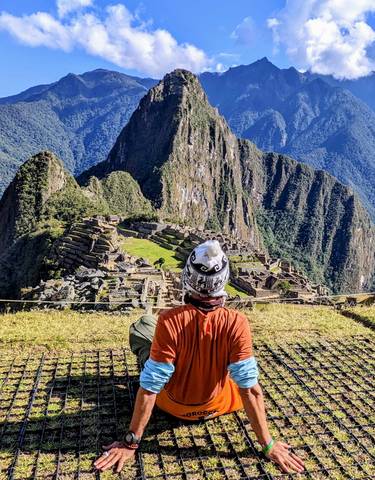 Scenic view of Machu Picchu with a person enjoying the view.