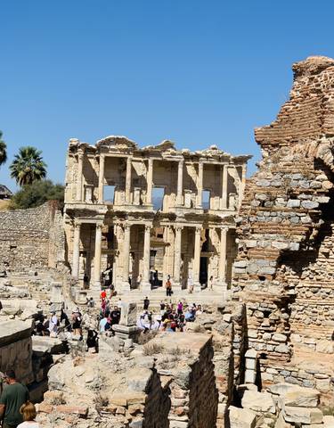 Ancient stone ruins of a Roman library with people visible.