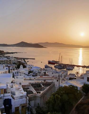 Sunset view over a coastal town with boats.