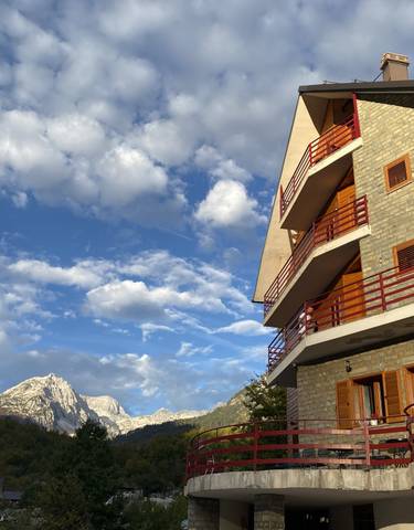 Scenic view of a mountain with a building and blue sky