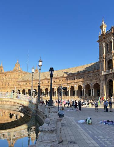 Plaza with historic buildings and people walking around.