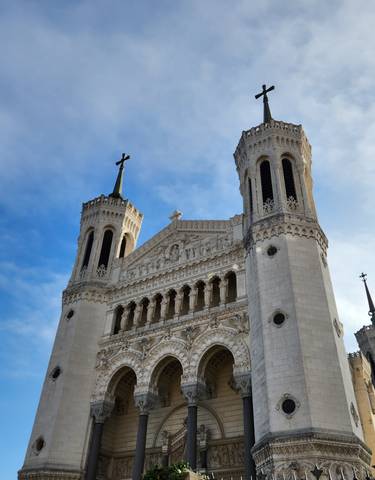 The Basilica of Notre-Dame de Fourvière against a blue sky.