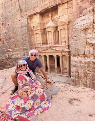 Two people posing with the iconic rock-cut architecture of Petra.