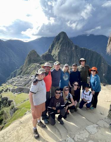 Group of people posing with Machu Picchu in the background.