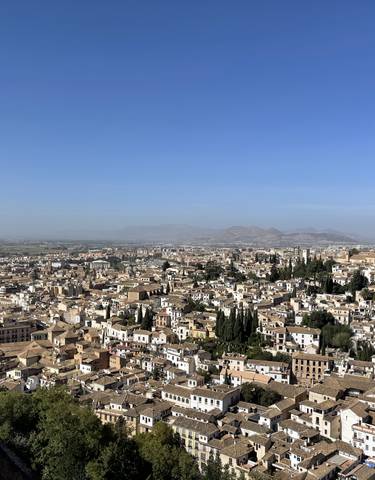 Panoramic view of a cityscape with mountains in the background.