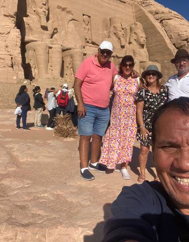 Tourists posing in front of Abu Simbel temple.