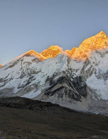 Sunlit snow-covered mountain peaks with dramatic lighting.