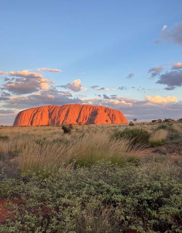 Uluru during sunset with clouds.
