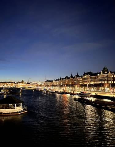 Night view of a city canal with lights reflecting on the water.