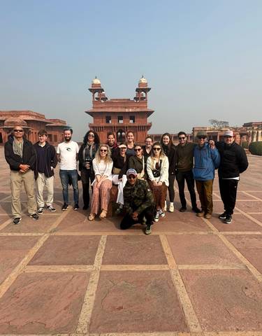 Group of tourists posing in front of a historic building.