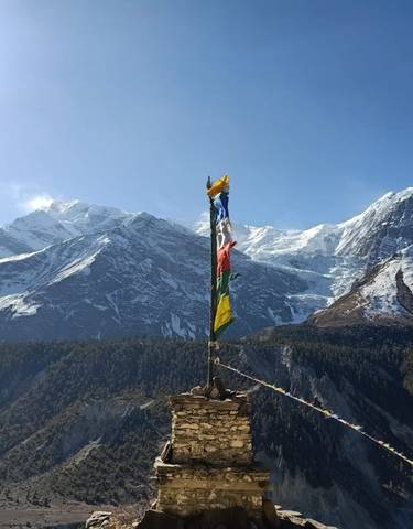 Snow-capped mountain peaks with prayer flags.