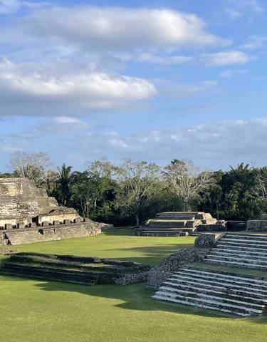 Ancient ruins with stepped pyramid structures under a clear blue sky