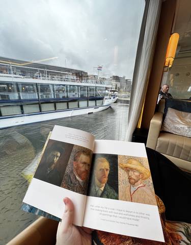 A book and the view of a boat through a window.