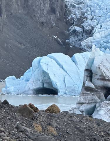 Massive blue glacier formations surrounded by rocky terrain.