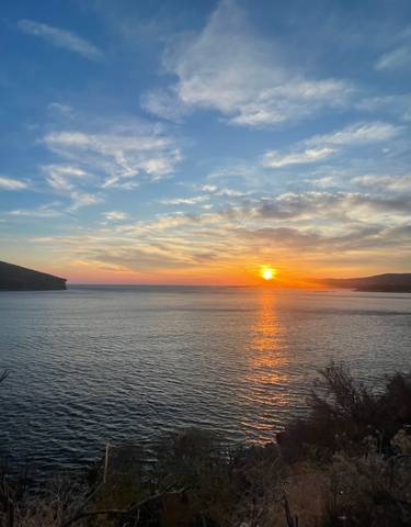 Sunset over the sea with a dramatic sky view.