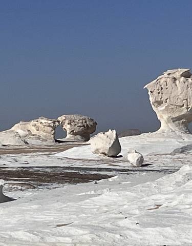 Rock formations in a desert landscape under a clear blue sky.