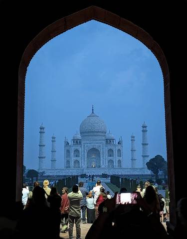 Taj Mahal framed by an arch during twilight.