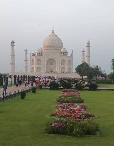 The Taj Mahal with gardens and visitors.