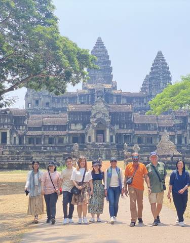 Group of people standing in front of a temple-like ancient structure.