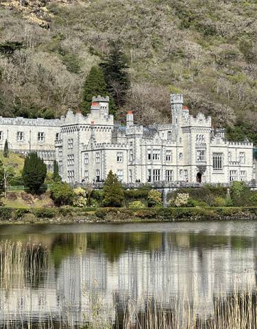 Stunning view of an architecturally impressive castle by a lake.