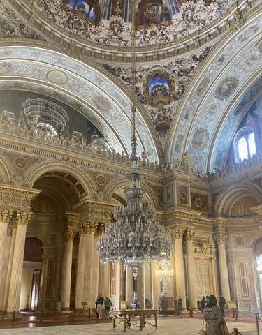 Intricate interior of a historic building with chandeliers and arches.