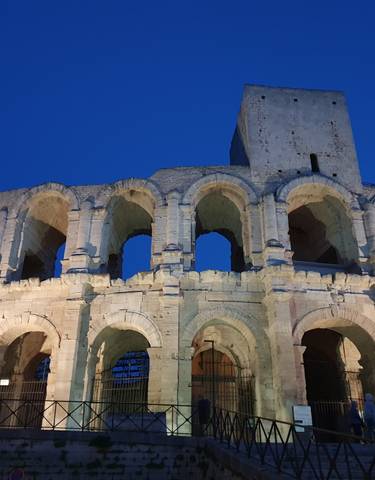Roman amphitheater illuminated at night.
