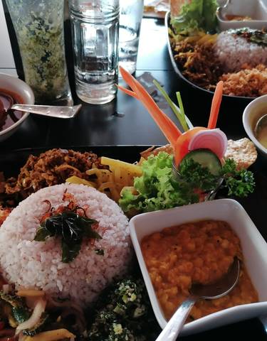 Assorted Sri Lankan dishes with rice, curry, and vegetables.