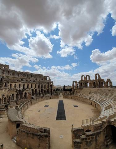 An ancient amphitheater with a dramatic sky.