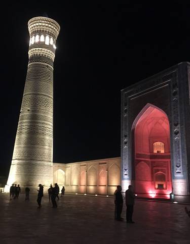 Mosque and minaret lit up at night.