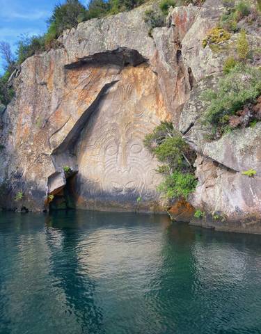 Maori rock carvings by the water.